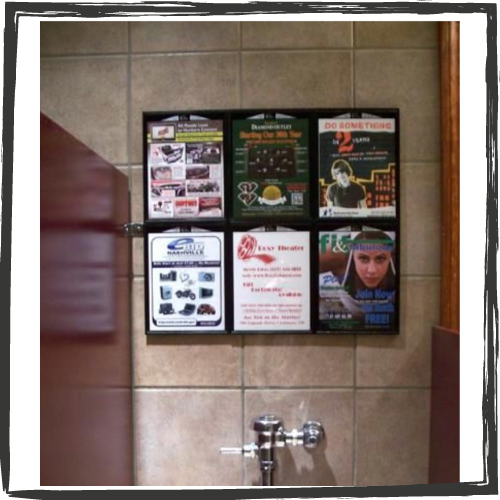 Inside a public toilet stall above the toile is a grid of 6 multi-colored ads for products and services