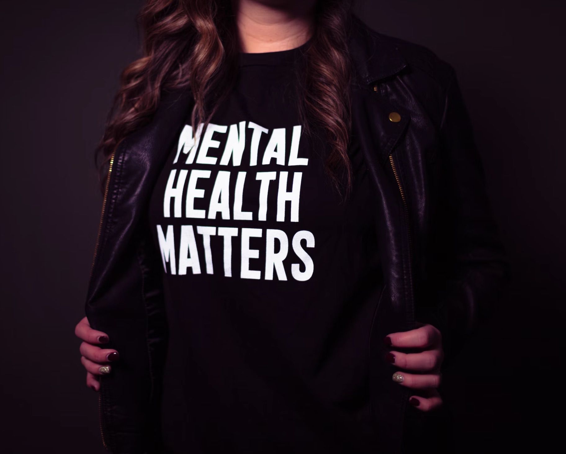 Photo of a person's torso wearing a black t-shirt that says, "Mental Health Matters" in white letters