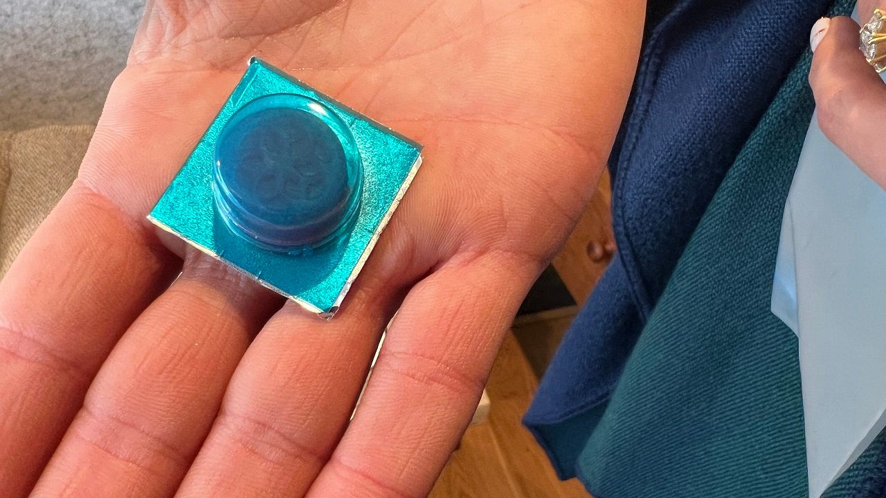 Photo of a large, blue lozenge in a bubble pack