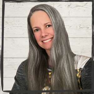 A smiling woman with long, silver-dark hair