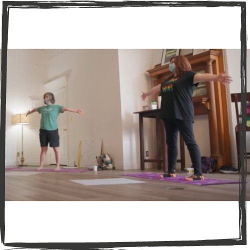 Photo of 2 white women in workout cloths stretching their arms wide as they dance on yoga mats
