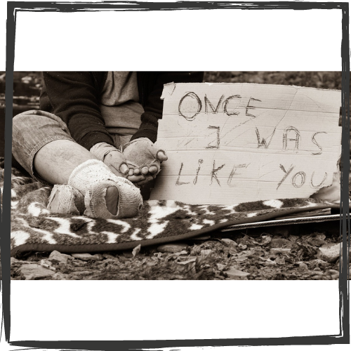 Photo of the lower portion of a person wearing ragged socks and gloves w/cupped hands extended and cardboard sign: "Once I was like you"