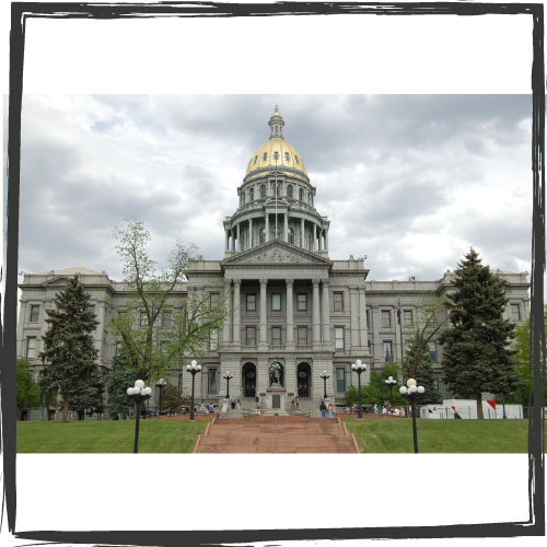 Photo of the front of the Colorado state capitol building with gray stone faced and gold dome