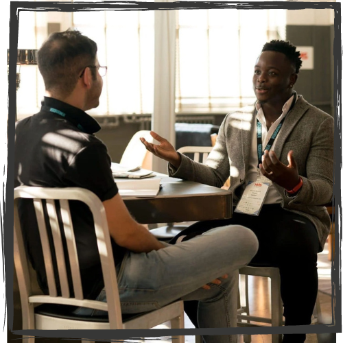 Photo of two men talking while seated