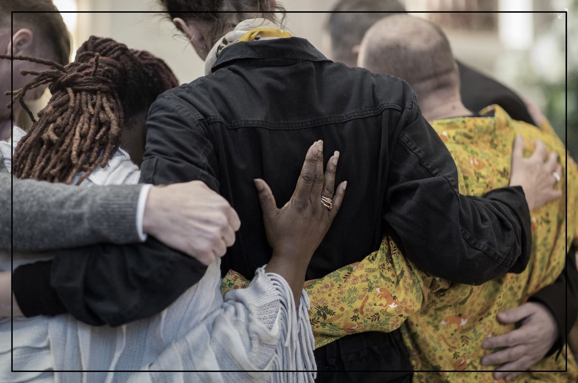 Photo of a diverse group hugging in a circle