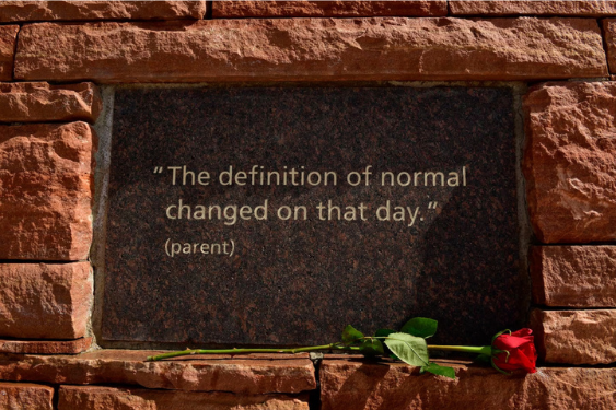 Red sandstone surrounds a reddish granite plaque: The definition of normal changed that day." (parent)